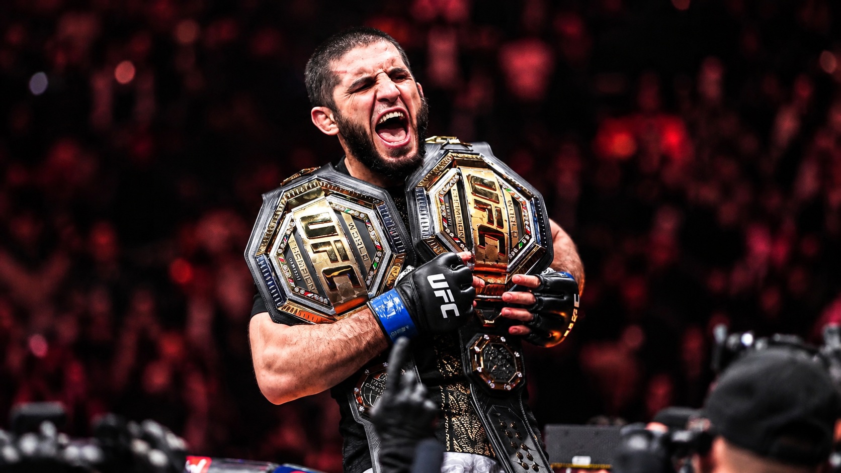 Islam Makhachev celebrating with UFC championship belts